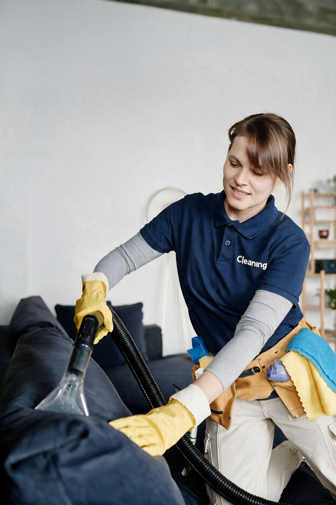Professional cleaner treating sofa upholstery in a London home